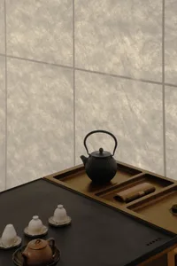 Cozy kitchen space with a wooden table, tea kettle, cups, and a bowl, featuring a warm and natural atmosphere
