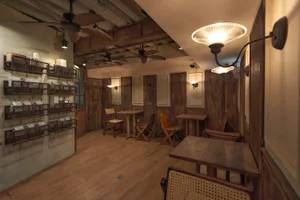 Warm and inviting living space with wooden floors and walls, featuring comfortable seating areas and a mix of natural and artificial lighting