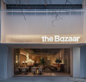 溫馨的餐廳用餐空間，設有多張餐桌、椅子、盆栽與獨特牆面設計