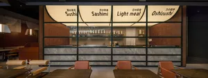 Modern Asian restaurant with a marble counter, sushi bar, and Japanese writing on the walls, creating an inviting atmosphere