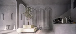 Modern living area with a couch, chair, and dining table, surrounded by a unique spiral-patterned wall and two potted plants, with a warm and inviting atmosphere