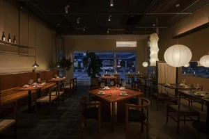Warm and inviting dining space with wooden tables and chairs, wine glasses, and a focus on comfort