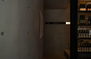 A functional hotel hallway with a white-painted concrete wall, featuring signs and a well-organized atmosphere