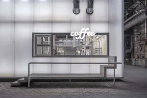 Industrial coffee processing facility with metal and glass surfaces, natural light, and machinery