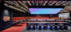 A modern dining area with rows of tables and chairs, featuring a sleek black and red color scheme, creating an inviting atmosphere for meals and socializing