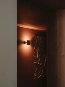Dark hallway with wood walls, lit by two lights on either side of a door