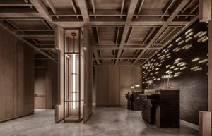 Dimly lit restaurant interior with wooden walls and floors, featuring two sinks and a modern aesthetic