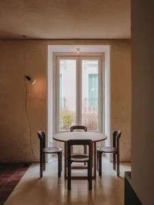 A warm and inviting dining area with a wooden table and chairs, surrounded by natural light from two windows