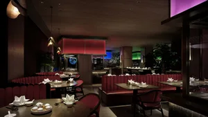Modern restaurant interior with red booths, wood, and metal elements, warm and inviting atmosphere
