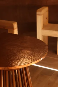 Two wooden chairs and a wooden table create a cozy seating area with a warm and inviting atmosphere