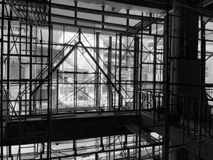 A building under construction with metal staircases leading to another level, showcasing progress and development