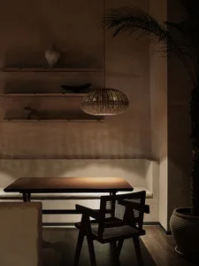 A cozy dining space with a wooden table surrounded by chairs, a vase, and a warm atmosphere