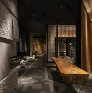 Bathroom with a wooden bench, potted plants, sink, and mirror, creating a calm and inviting atmosphere