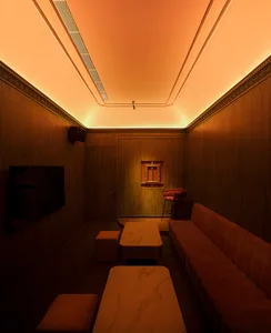 A well-lit living space with a marble dining table, two couches, and a warm atmosphere