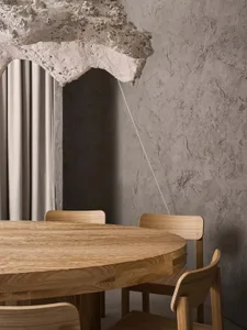 A wooden table surrounded by four chairs in a cozy dining area with a warm atmosphere
