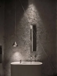 Bathroom with a white marble sink, large mirror, and two faucets, giving a modern and luxurious feel