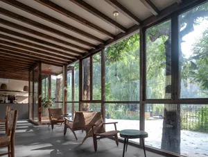 Well-lit living area with wood flooring, large windows, and comfortable seating options