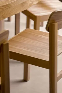 A wooden chair on a hardwood floor in a professional and organized space with other chairs in the background