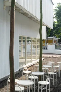 A patio area with white chairs arranged around a dining table, creating a comfortable seating space for socializing and relaxation