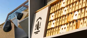 一座現代建築，立面設計活潑有趣，外牆上附有木製鳥屋