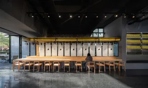 A restaurant interior with wooden tables and chairs, creating a warm and inviting atmosphere for socializing and dining