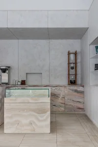 Modern kitchen with a marble countertop, sink, and cabinets, featuring a dining area