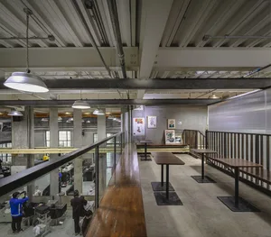 A spacious dining and social space with multiple tables and chairs, inviting atmosphere, and ample seating options