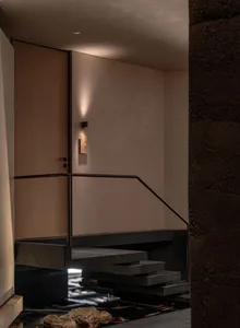 A warm and inviting interior staircase with wooden steps and a metal railing, illuminated by natural light