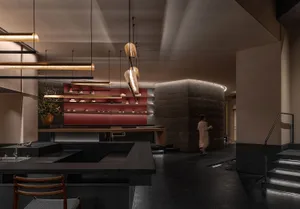 Elegant dining space with a long wooden counter, chairs, and a potted plant, providing a comfortable and inviting atmosphere for guests