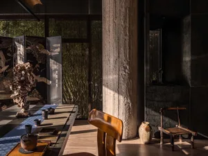 A cozy dining space with a wooden table and glass accents, surrounded by chairs and well-lit by natural sunlight