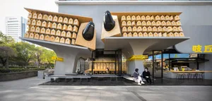 A bustling cafe with multiple benches and chairs around dining tables, creating a warm and inviting atmosphere for socializing and relaxation