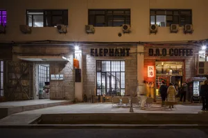 A well-lit Asian restaurant at night with a prominent sign reading Elephant and outdoor seating for customers