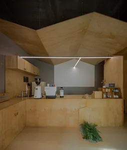 Warm and inviting kitchen with wooden floors and walls, featuring coffee makers and cups on the countertop