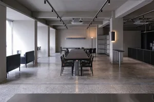 A well-lit conference room with a large dining table and chairs, suggesting a space for meetings and gatherings