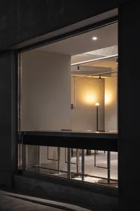A well-lit dining area with a symmetrical seating arrangement, surrounded by glass and natural light