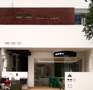 誘人的店面，白色建築搭配綠椅與餐桌，吸引顧客探索室內設計作品