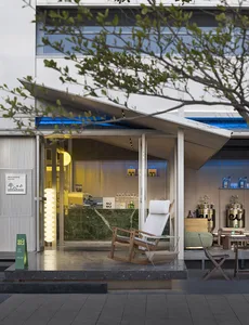 An inviting outdoor cafe with a modern design, featuring a patio area with chairs and dining tables, wood and metal elements, and a relaxed atmosphere