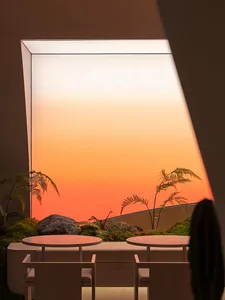 Three round tables and chairs in a well-lit dining area with natural light from large windows