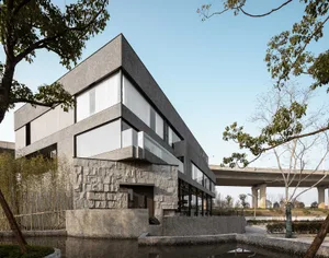 Elegant modern building with a gray stone exterior and multiple windows, set against a clear sky
