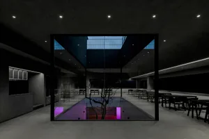 A modern indoor pool area with chairs around the pool, featuring a purple glow and well-lit surroundings
