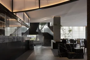 A well-designed interior space with a stone staircase, multiple potted plants, and a sophisticated atmosphere