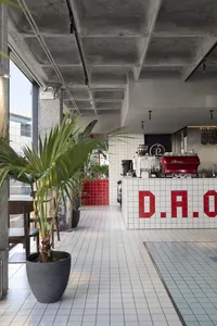 現代餐廳內部，吧台設有咖啡機與水槽，周圍環繞盆栽植物與座椅，營造乾淨整潔的氛圍