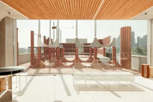 Open indoor space with a brick wall, wooden ceiling, and benches, featuring a mix of modern and traditional elements