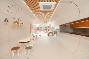 Modern restaurant interior with multiple dining tables, chairs, and tiled flooring