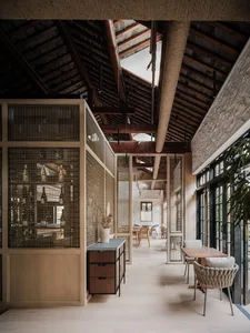 Inviting open concept living area with a dining table, chairs, and decorative bottles, surrounded by warm and comfortable elements