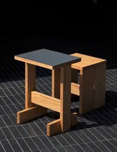 A modern dining space with a wooden table and black countertop on a tiled floor, giving a clean and minimalist appearance