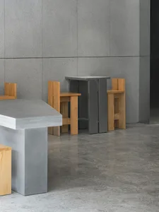 Empty restaurant with grey walls and floors, wooden chairs, and dining tables, with a clean and well-organized atmosphere