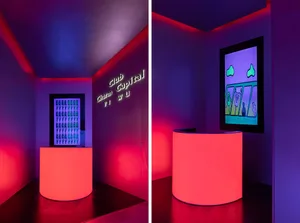 A modern bar lounge with a pink glow, featuring bottles and chairs in a stylish setting