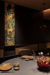 Cozy dining area with a wooden table, chairs, and various decorative items, suggesting a warm and inviting atmosphere