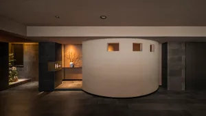 A bright and airy interior design concept featuring a circular room with a curved wall, large windows, and concrete walls
